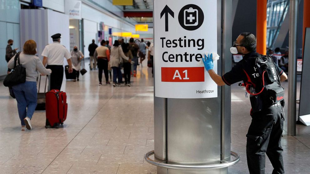 PHOTO: A worker sanitizes a sign at the International arrivals area of Terminal 5 in London's Heathrow Airport, Britain, Aug. 2, 2021.