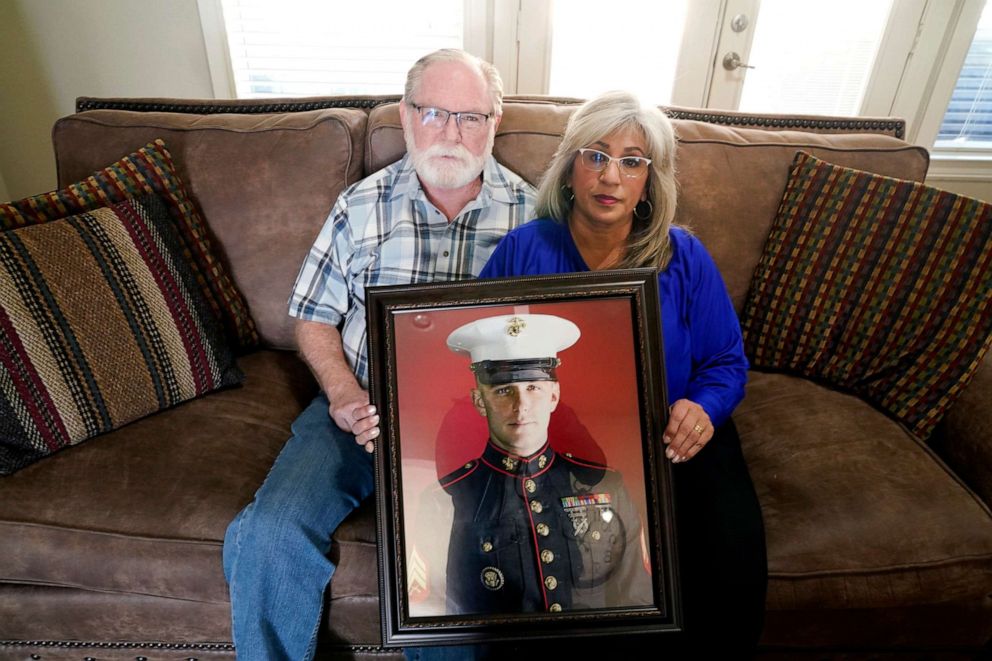 PHOTO: Joey and Paula Reed pose for a photo with a portrait of their son Marine veteran and Russian prisoner Trevor Reed at their home in Fort Worth, Texas, Feb. 15, 2022.