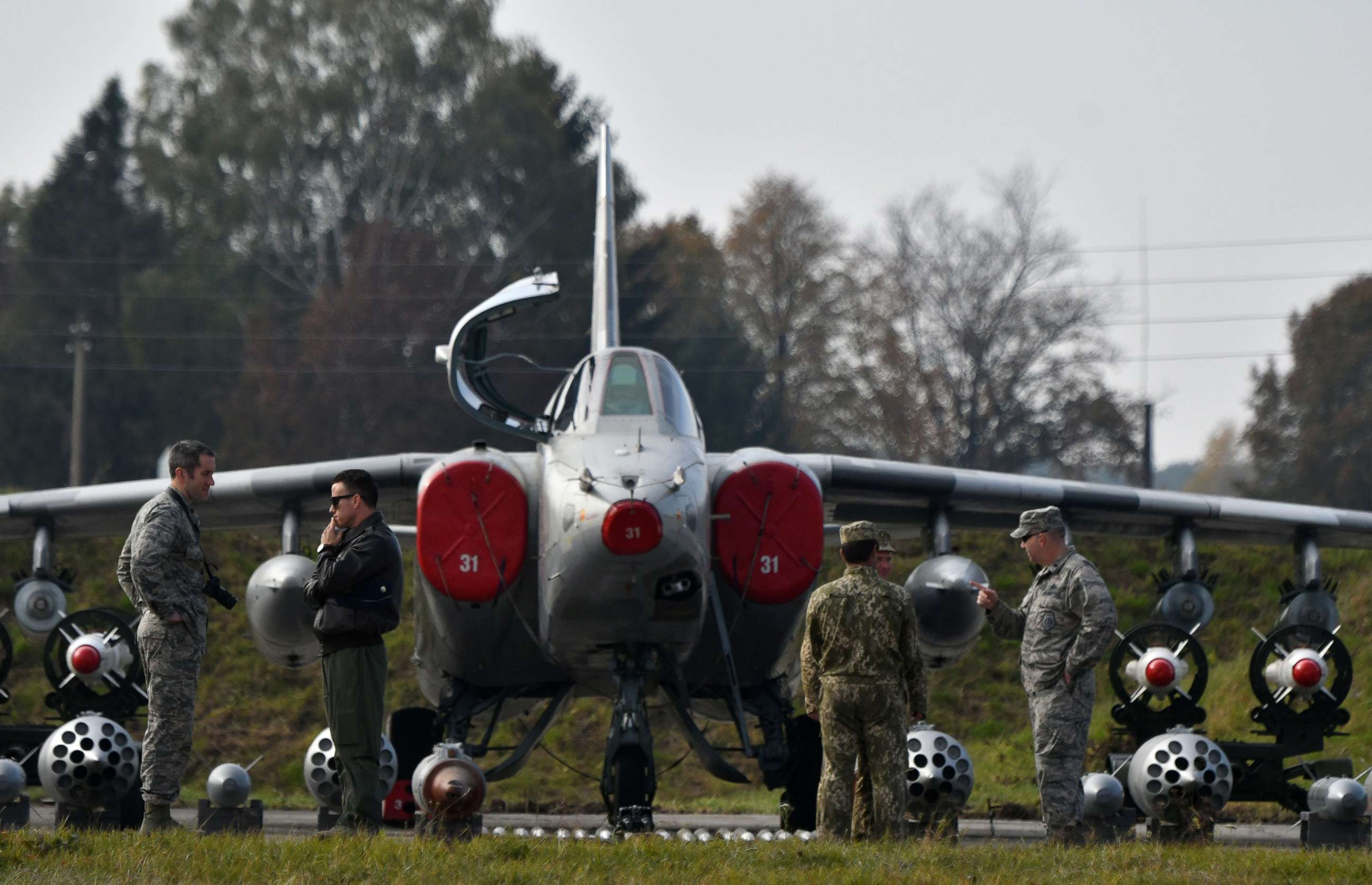 PHOTO: Ukrainian and US servicemen speak together in front of the Ukrainian SU-25 low-flying attack aircraft during an air force exercise on Starokostyantyniv military airbase on October 12, 2018.