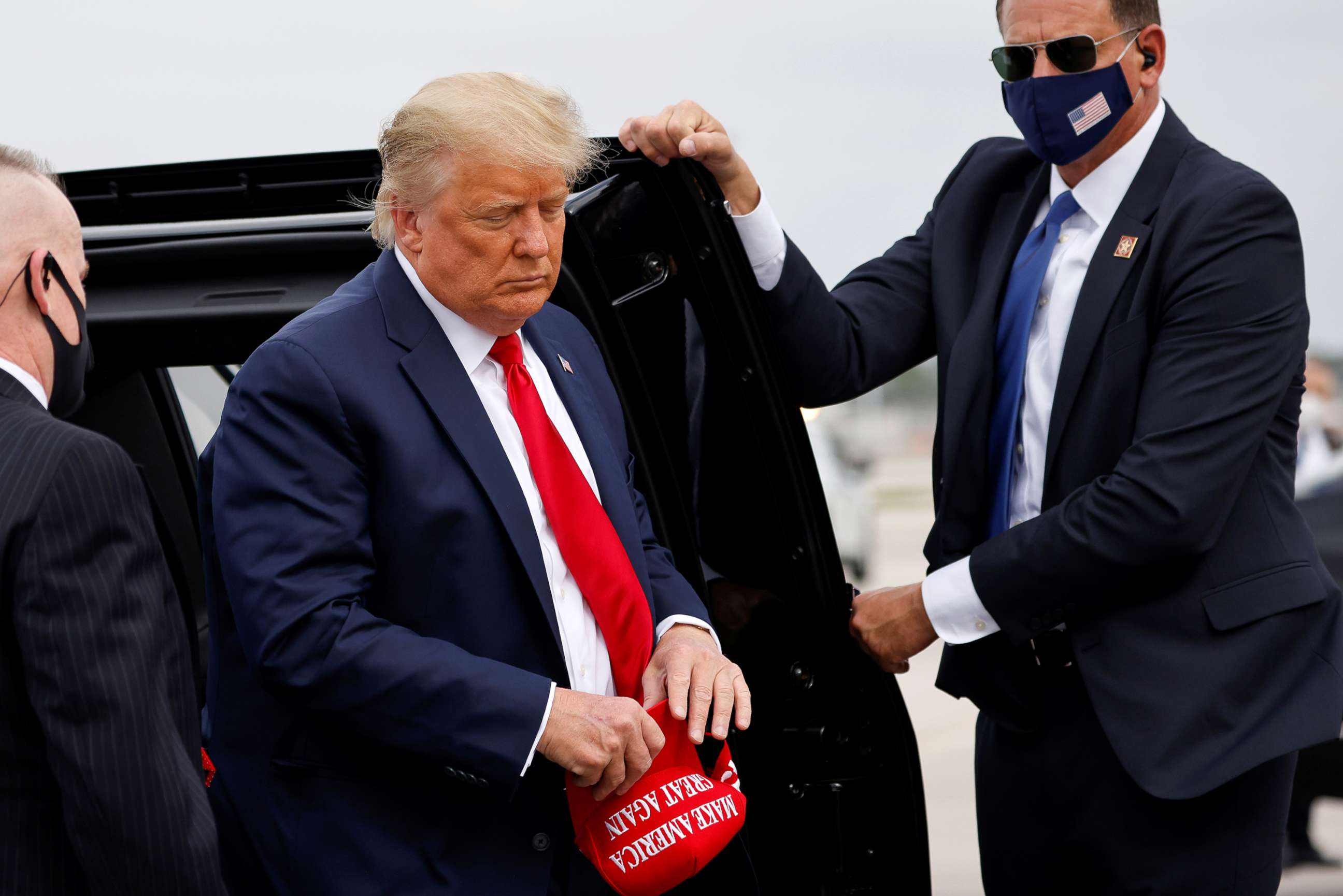 PHOTO: President Donald Trump holds a 'Make America Great Again' cap while arriving to board Air Force One as he departs Florida for campaign travel at Miami International Airport in Miami, Nov. 2, 2020.