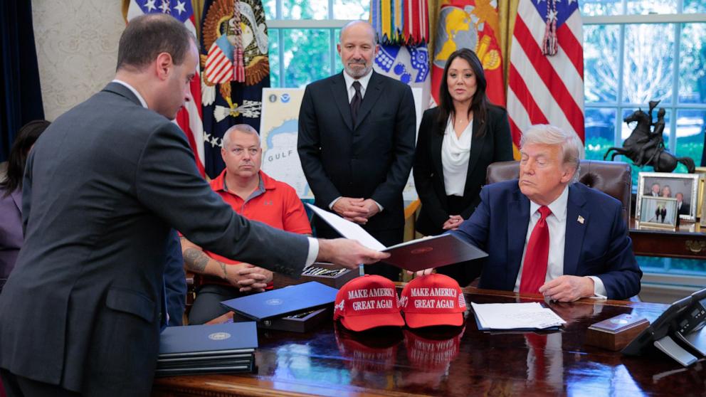 PHOTO:  White House staff secretary Will Scharf (L) hands President Donald Trump an executive order to sign in the Oval Office at the White House, April 23, 2025.