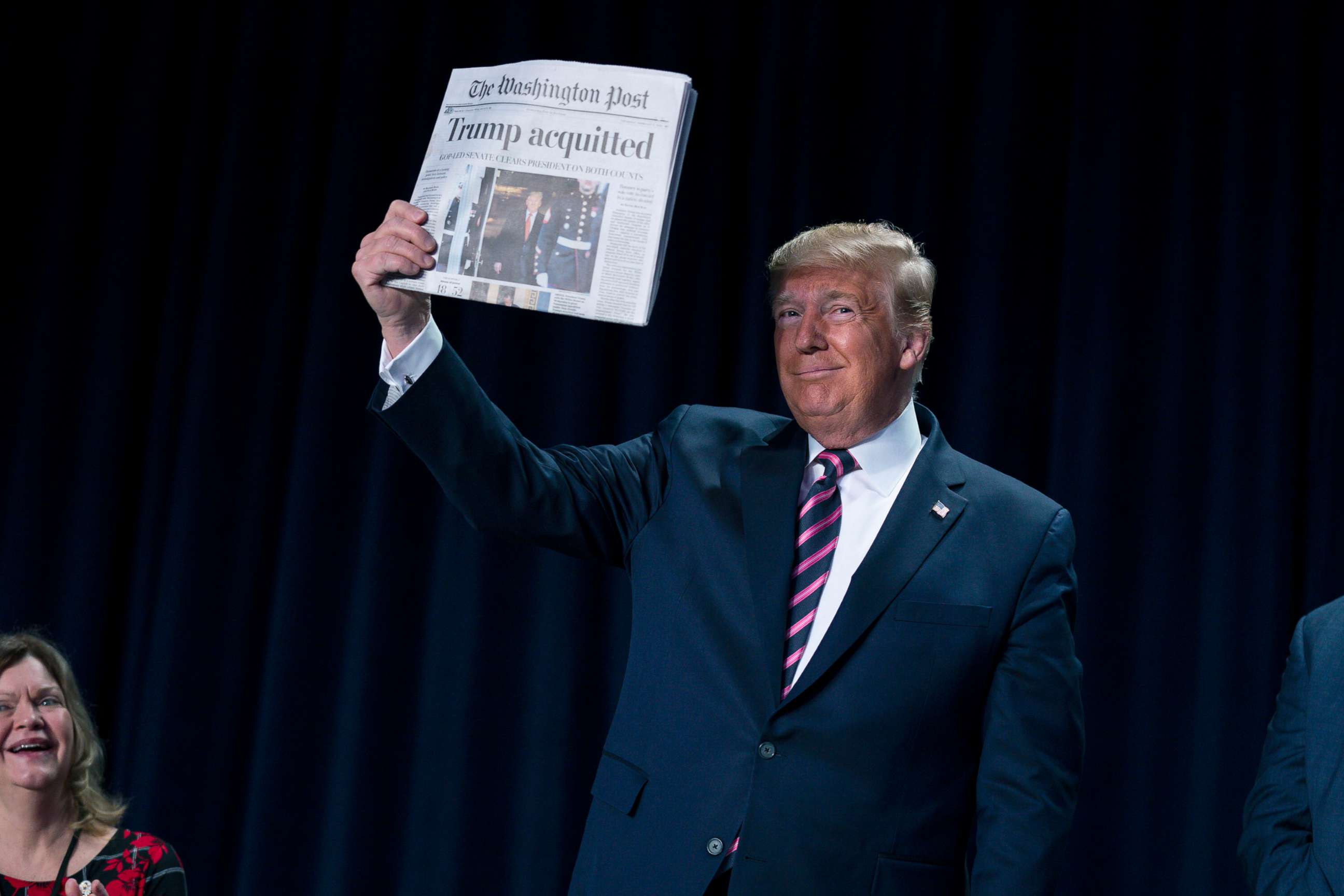 PHOTO: President Donald Trump holds up a newspaper with the headline that reads "Trump acquitted" during the 68th annual National Prayer Breakfast, Feb. 6, 2020, in Washington, D.C.
