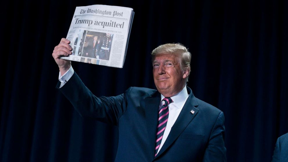 PHOTO: President Donald Trump holds up a newspaper with the headline that reads "Trump acquitted" during the 68th annual National Prayer Breakfast, Feb. 6, 2020, in Washington, D.C.