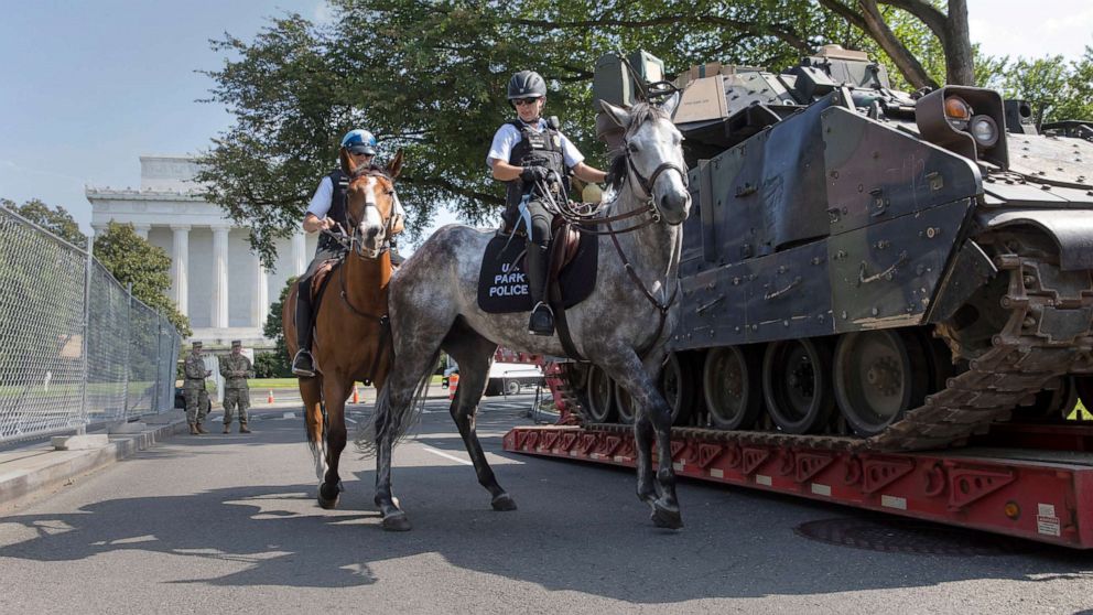 PHOTO: Mounted US Park Police pass by an armored Bradley Fighting Vehicle near the Lincoln Memorial as preparations continue for Independence Day celebrations on the National Mall in Washington, D.C., July 3, 2019. 
