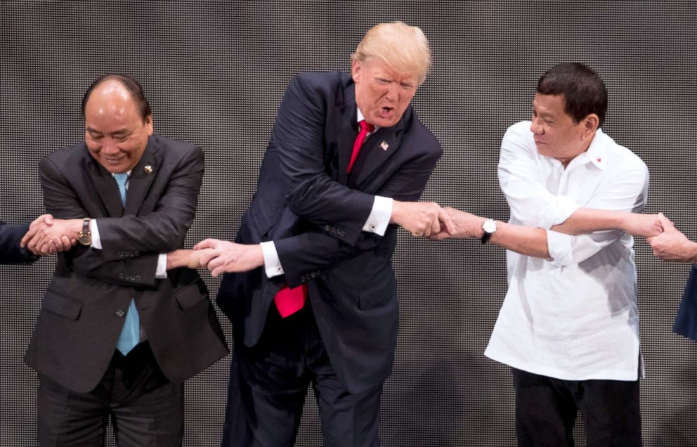 PHOTO: President Donald Trump, center, reacts as he does the "ASEAN-way handshake" with Vietnamese Prime Minister Nguyen Xuan Phuc, left, and Philippines President Rodrigo Duterte at the ASEAN Summit, Nov. 13, 2017, in Manila, Philippines.