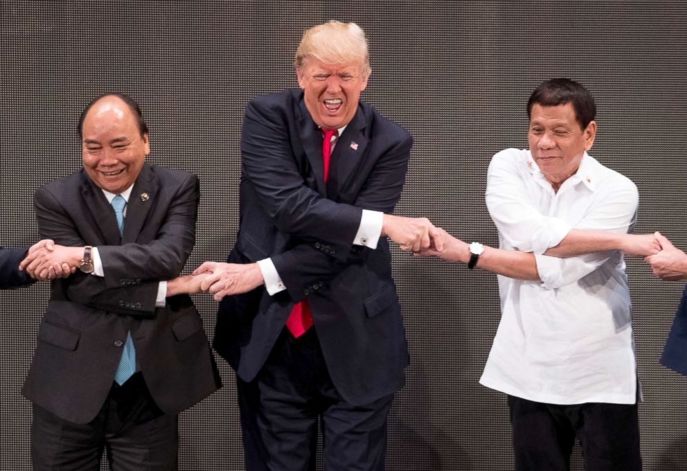 PHOTO: President Donald Trump, center, reacts as he does the "ASEAN-way handshake" with Vietnamese Prime Minister Nguyen Xuan Phuc, left, and Philippine President Rodrigo Duterte at the ASEAN Summit, Nov. 13, 2017, in Manila, Philippines.