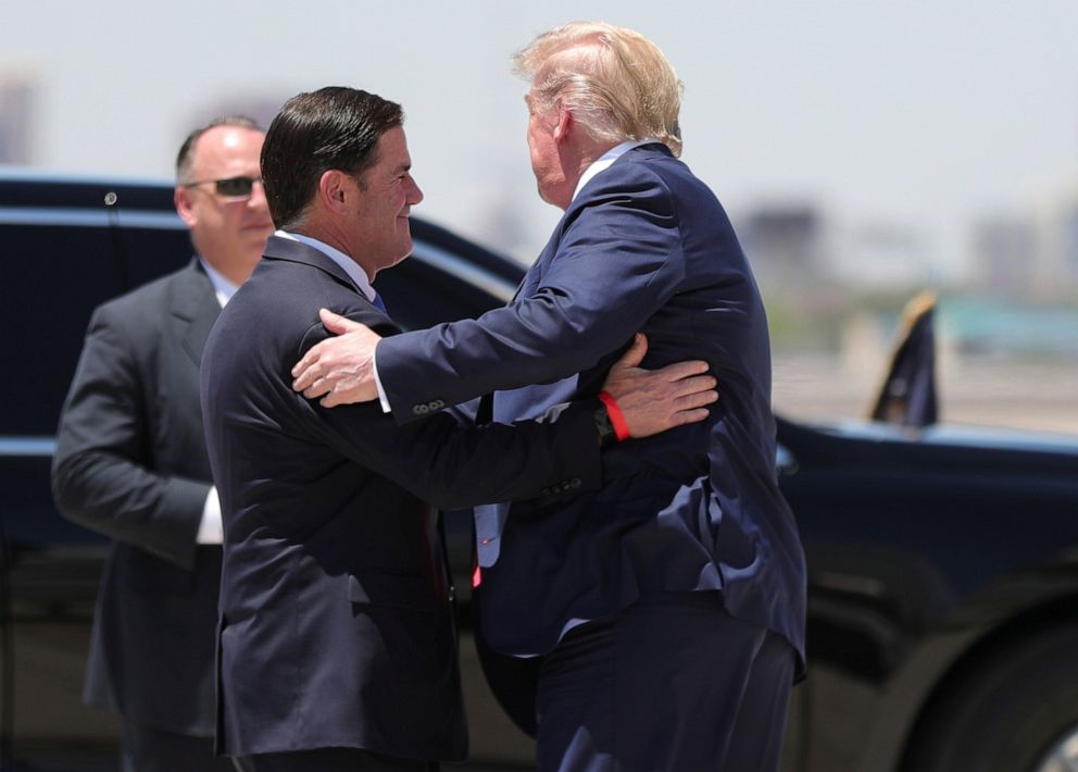 PHOTO: President Donald Trump hugs Arizona Governor Doug Ducey as he arrives at Sky International Airport to tour a nearby Honeywell facility manufacturing protective masks for the coronavirus disease (COVID-19) pandemic in Phoenix, May 5, 2020.