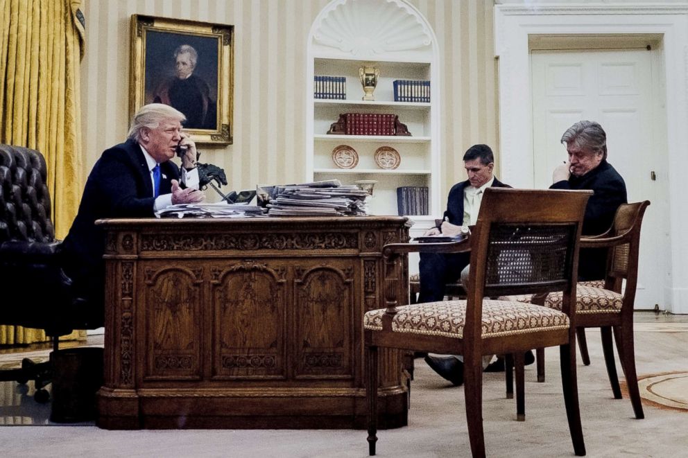 PHOTO: President Donald Trump, left, speaks on the phone while National Security Advisor Michael Flynn, Chief Strategist Steve Bannon listen, in the Oval Office, Jan. 28, 2017. 