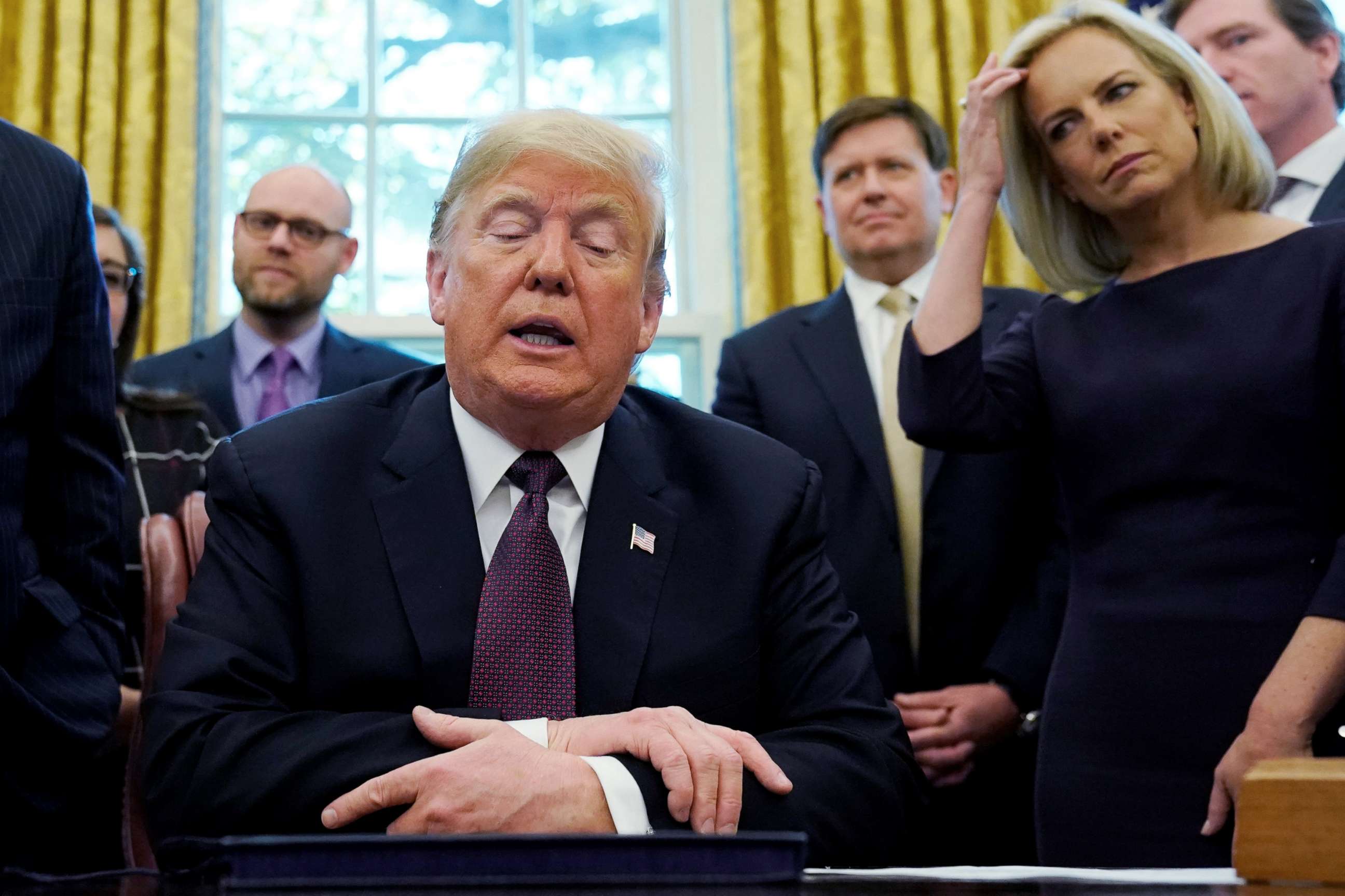 PHOTO: President Donald Trump talks to reporters as Department of Homeland Security Secretary Kirstjen Nielsen, right, looks on at a signing ceremony in the Oval Office of the White House, Nov. 16, 2018.