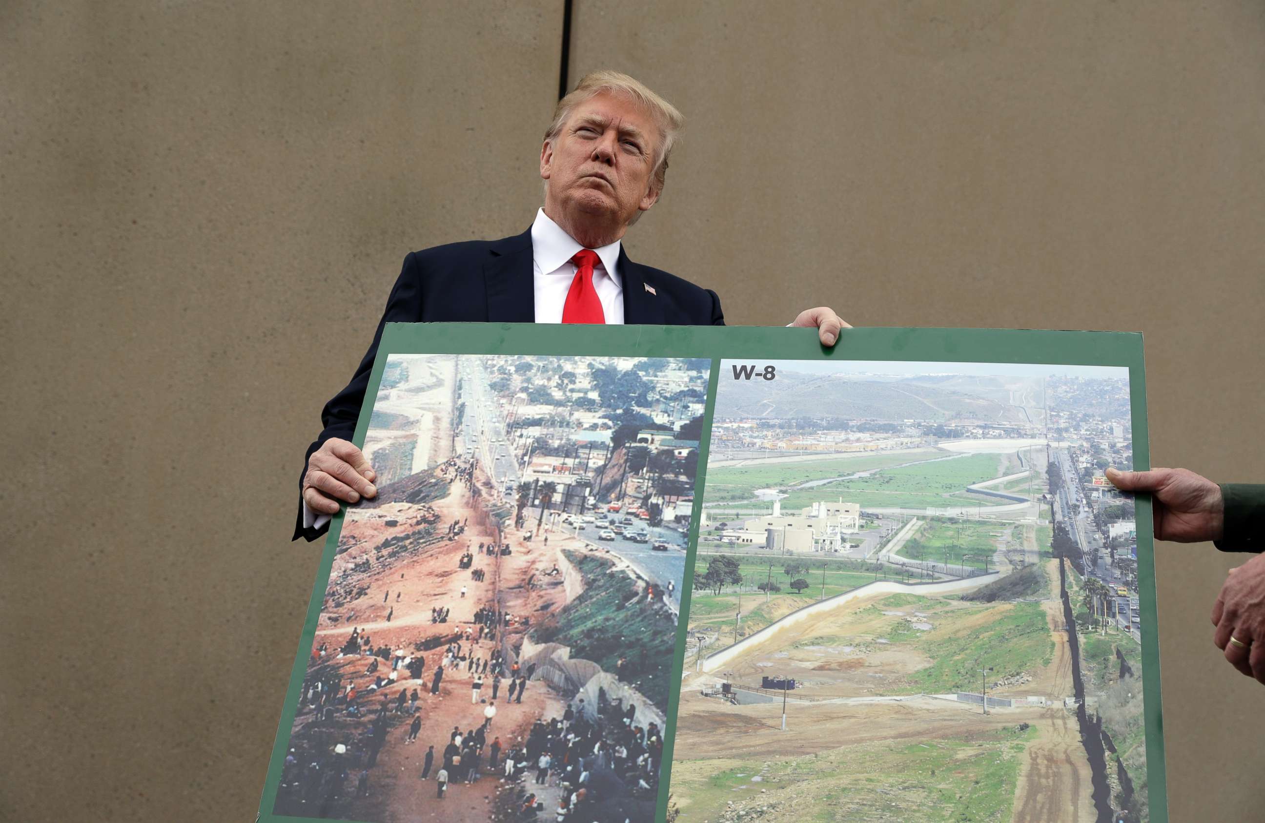 PHOTO: President Donald Trump holds an image of the border area as he speaks during a tour to review border wall prototypes, March 13, 2018, in San Diego.