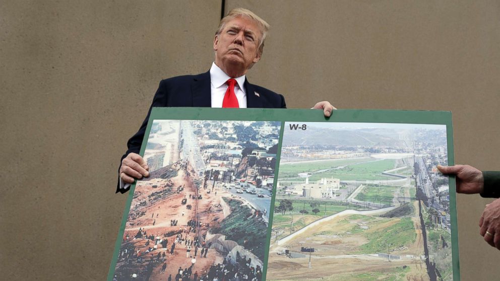 PHOTO: President Donald Trump holds an image of the border area as he speaks during a tour to review border wall prototypes, March 13, 2018, in San Diego.