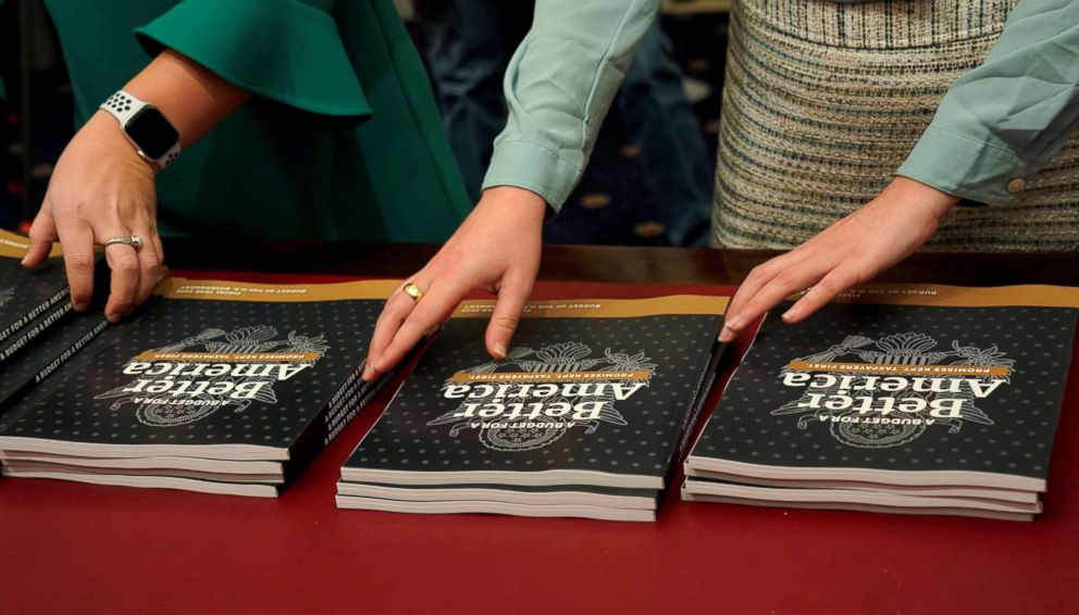 PHOTO: Aides place copies of Volume 1 of U.S. President Donald Trump's budget for Fiscal Year 2020 on a table after it was delivered by the Office of Management and Budget  to the House Budget Committee room on Capitol Hill in Washington, March 11, 2019.