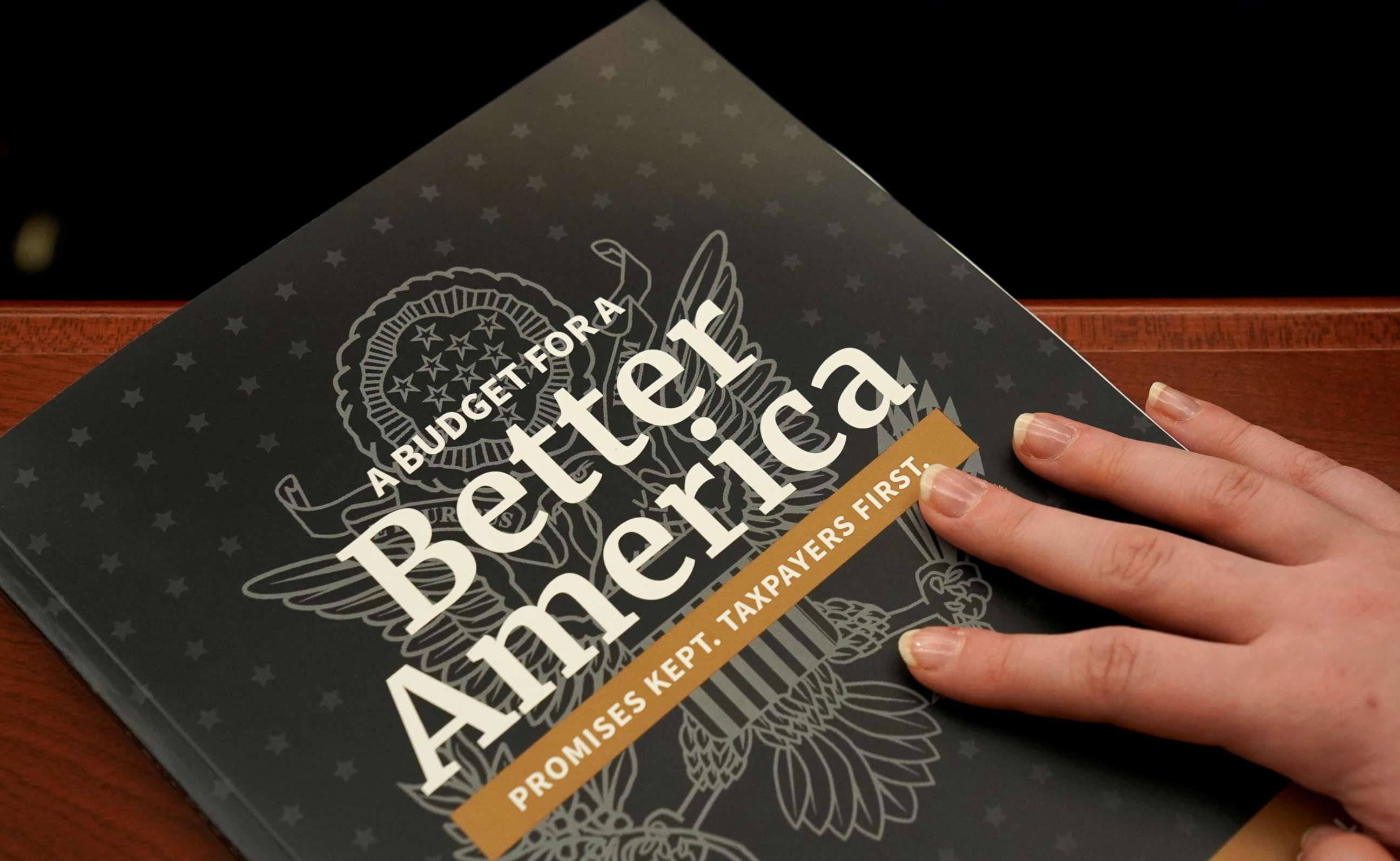 PHOTO: An aide puts her hand on a copy of Volume 1 of U.S. President Donald Trump's budget for Fiscal Year 2020 after it was delivered to the House Budget Committee room on Capitol Hill in Washington, March 11, 2019.