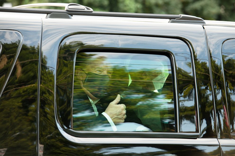PHOTO: President Donald Trump wears a protective mask while giving a thumbs up as he is driven in a motorcade past supporters outside of Walter Reed National Military Medical Center in Bethesda, Md., Oct. 4, 2020.