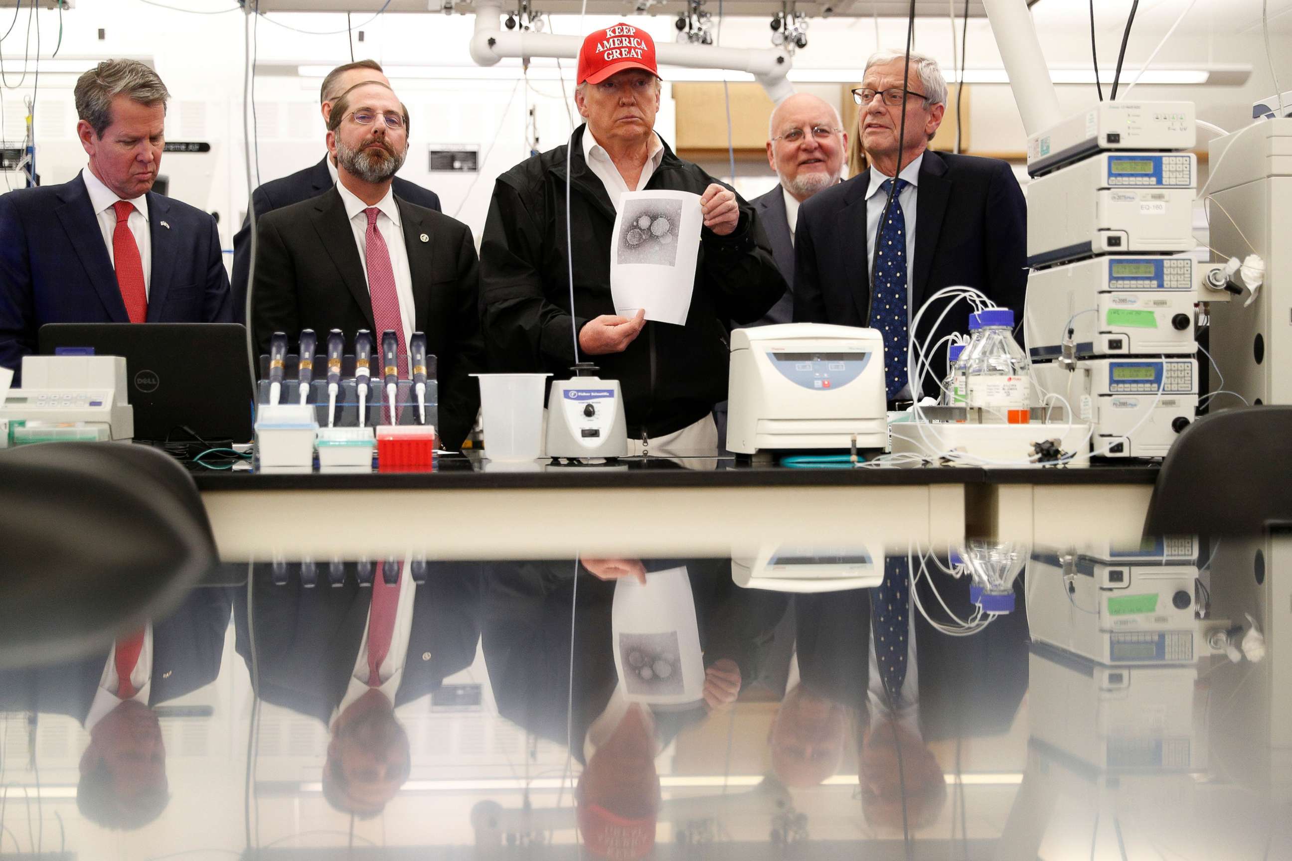PHOTO: President Donald Trump displays a photo of COVID-19 beside Georgia Governor Brian Kemp, HHS Secretary Alex Azar and CDC Associate Director for Laboratory Science and Safety Steve Monroe, at the Center for Disease Control in Atlanta, March 6, 2020.