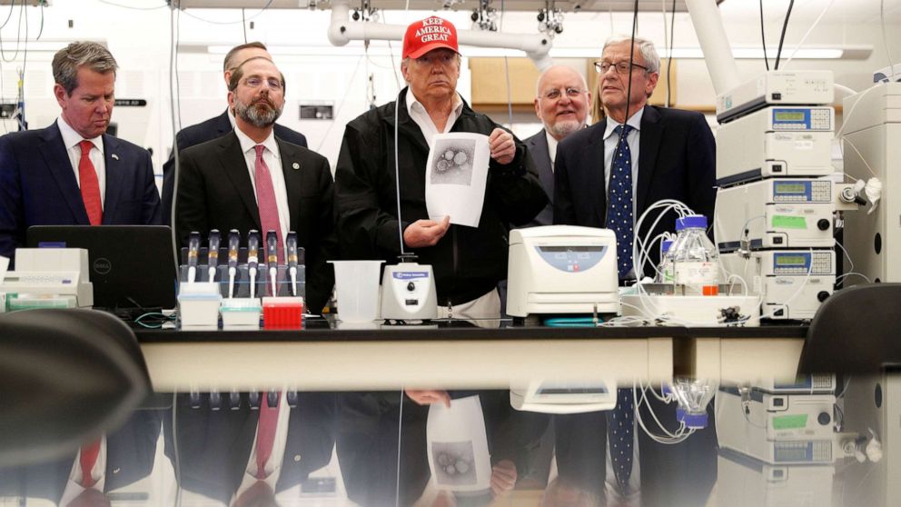 PHOTO: President Donald Trump displays a photo of COVID-19 beside Georgia Governor Brian Kemp, HHS Secretary Alex Azar and CDC Associate Director for Laboratory Science and Safety Steve Monroe, at the Center for Disease Control in Atlanta, March 6, 2020.