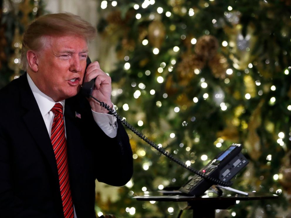   PHOTO: President Donald Trump speaks on-the-phone updates to follow Santa's tracker movements of NORAD's Santa Tracker on December 24, 2018. 