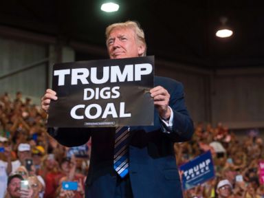 PHOTO: President Donald Trump holds up a Trump Digs Coal sign as he arrives to speak during a Make America Great Again Rally at Big Sandy Superstore Arena in Huntington, W. Va., Aug. 3, 2017.