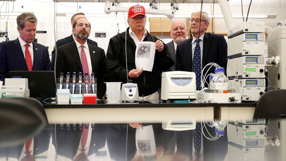 PHOTO: President Donald Trump displays a photo of the COVID-19 Coronavirus during a tour of the Center for Disease Control in Atlanta, March 6, 2020.