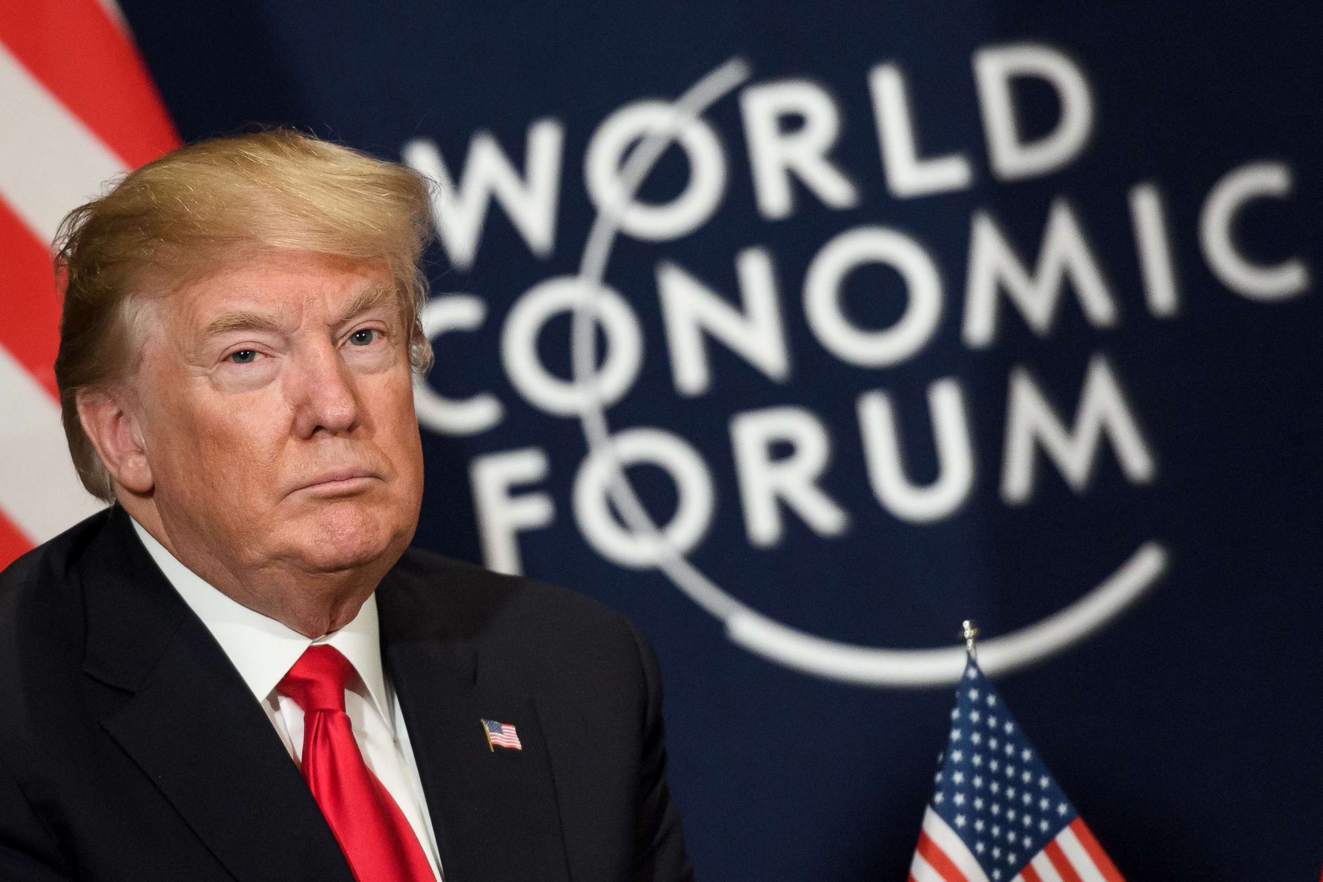 PHOTO: President Donald Trump looks on as he sits next to the logo of the World Economic Forum annual meeting, Jan. 26, 2018, in Davos, Switzerland.