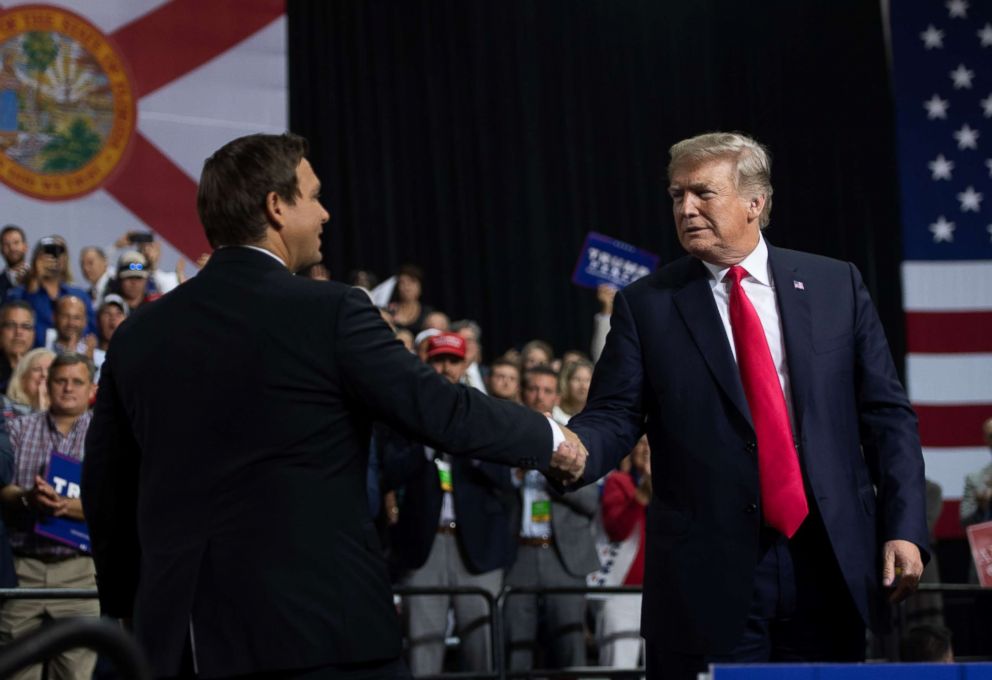 PHOTO: President Donald Trump shakes hands with Representative Ron DeSantis, Republican candidate for Florida Governor, as he speaks during a campaign rally at Florida State Fairgrounds Expo Hall in Tampa, Fla., July 31, 2018.