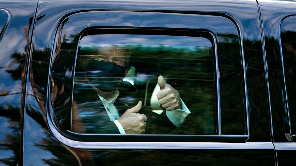 PHOTO: President Donald Trumpm who tested positive for COVID-19, greets supporters during a drive by outside of Walter Reed National Military Medical Center, Oct. 4, 2020, in Bethesda, Md.