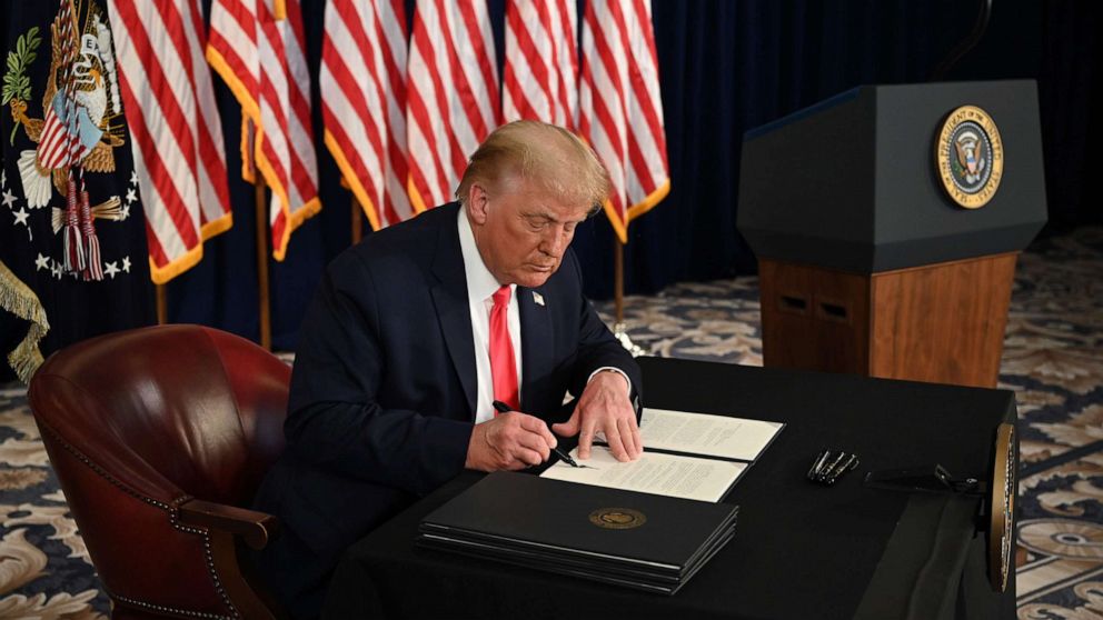 PHOTO: President Donald Trump signs an executive orders extending coronavirus economic relief, during a news conference in Bedminster, N.J., on Aug.8, 2020.