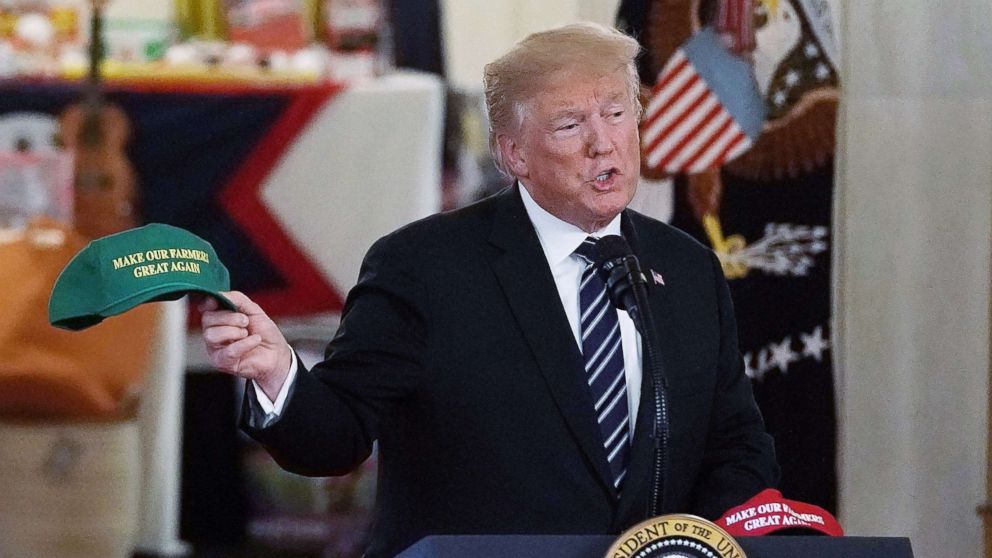 PHOTO: President Donald Trump holds up a "Make Our Farmers Great Again" hat as he speaks during the 2018 Made in America Product Showcase event, July 23, 2018, in the Cross Hall of the White House in Washington, D.C.