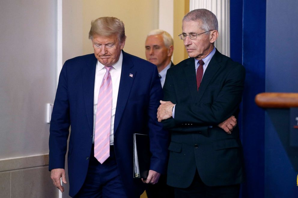 PHOTO: President Donald Trump walks past Dr. Anthony Fauci, right, director of the National Institute of Allergy and Infectious Diseases, as he arrives to speak at a coronavirus task force briefing at the White House, April 4, 2020, in Washington.