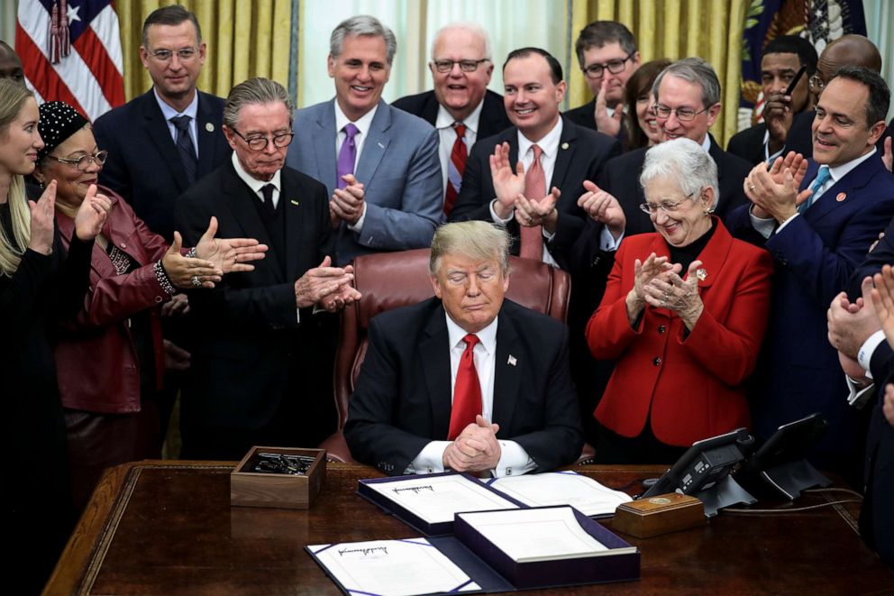 PHOTO: Members of the Congress and guests react after President Donald Trump signed the First Step Act and the Juvenile Justice Reform Act in the Oval Office of the White House, Dec. 21, 2018.