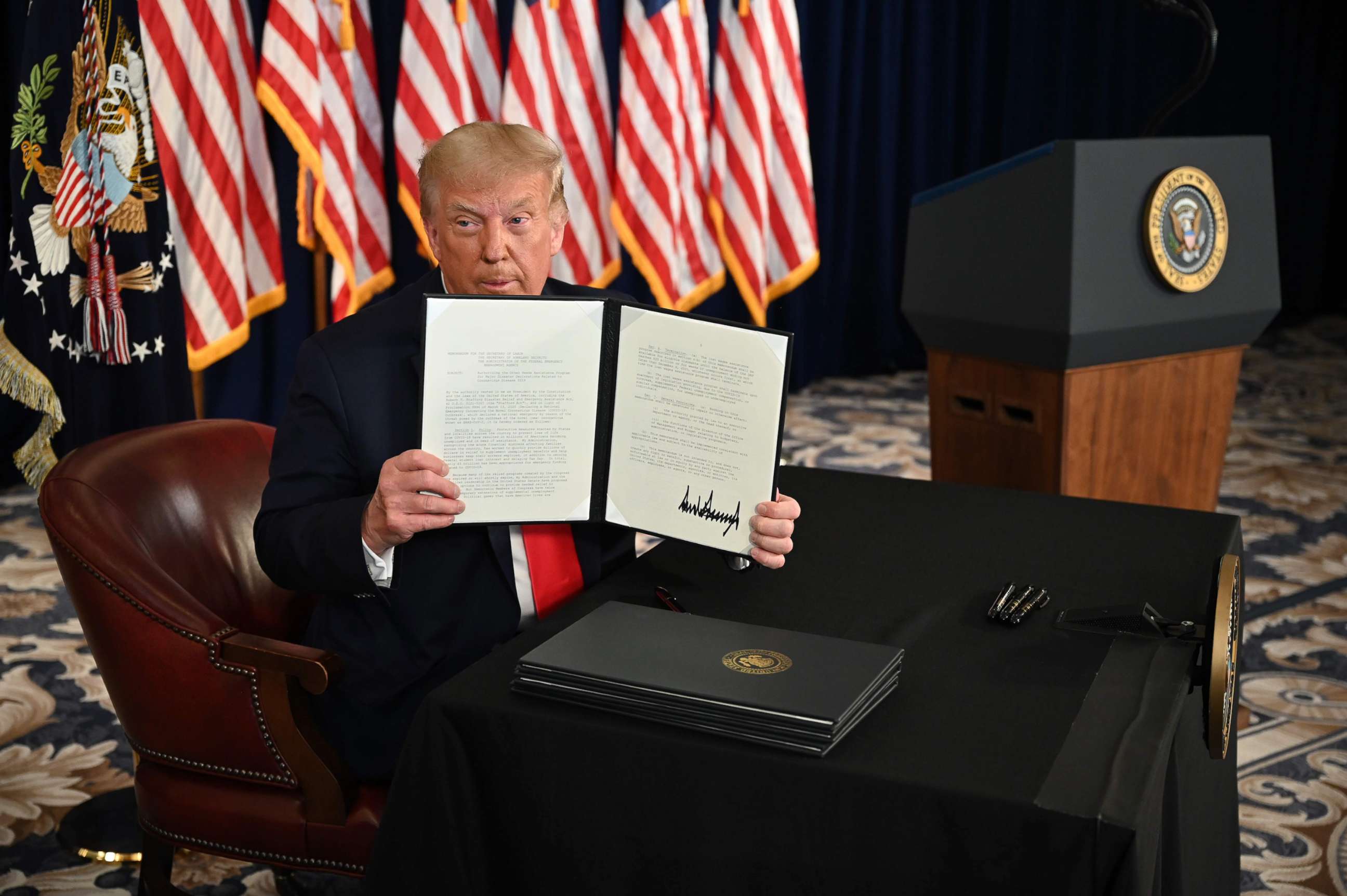 PHOTO: President Donald Trump signs executive orders extending coronavirus economic relief, during a news conference in Bedminster, N.J., on Aug. 8, 2020.