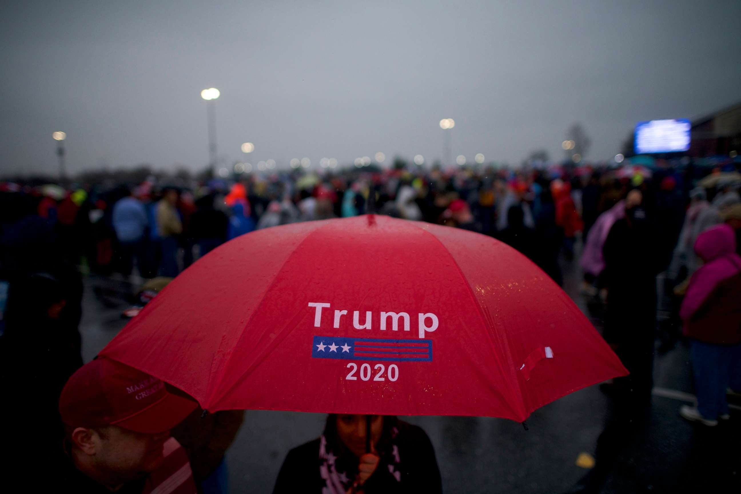 PHOTO: Supporters holding a "Trump 2020" umbrella wait in the rain before President Donald Trump holds a campaign rally, Dec. 10, 2019, in Hershey, Penn.