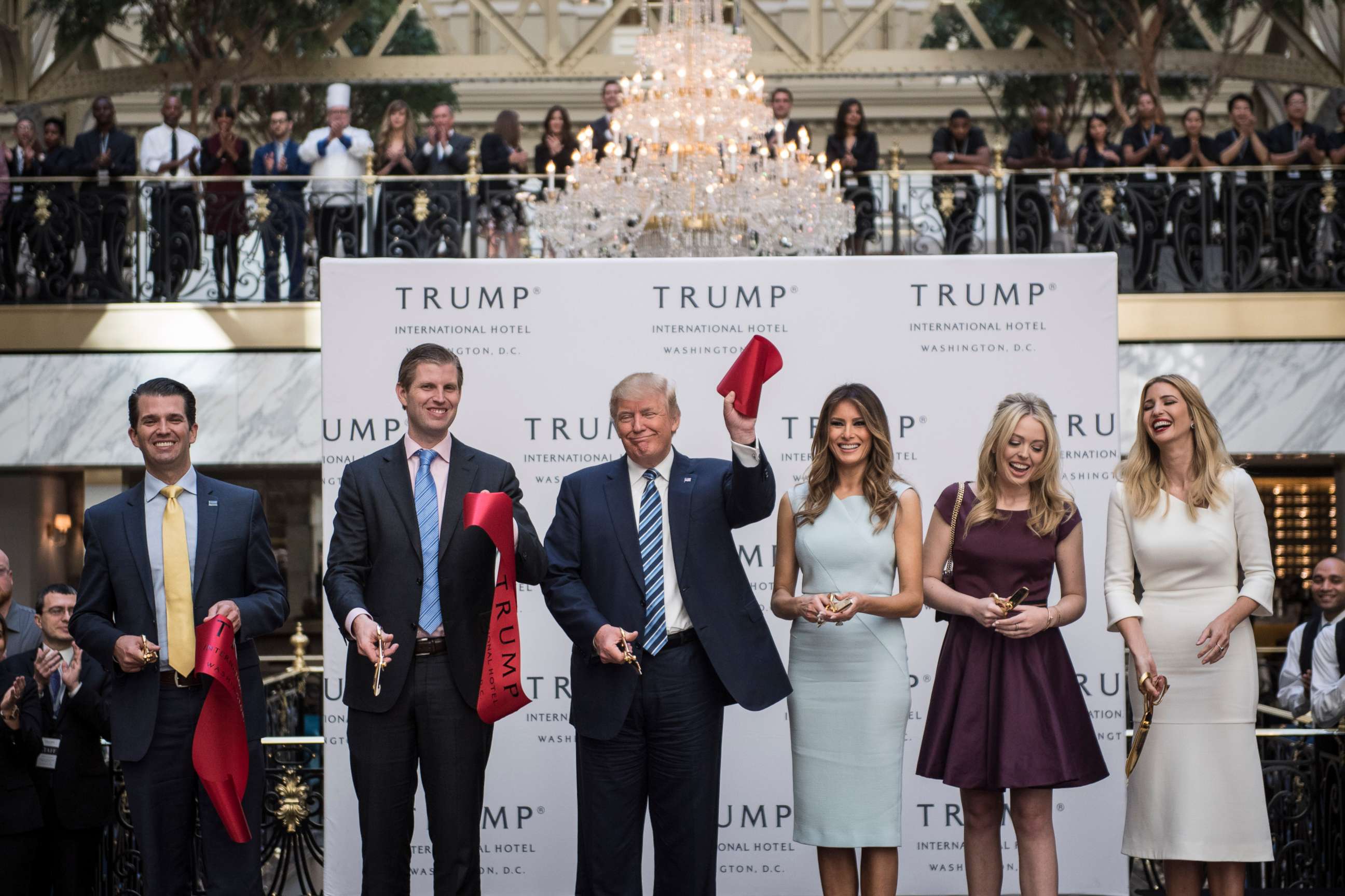 PHOTO: Donald Trump, accompanied by, from left, Donald Trump Jr., Eric Trump, Trump, Tiffany Trump, Melania Trump and Ivanka Trump, holds up a ribbon during the grand opening ceremony of the Trump International Hotel in Washington, Oct. 26, 2016.