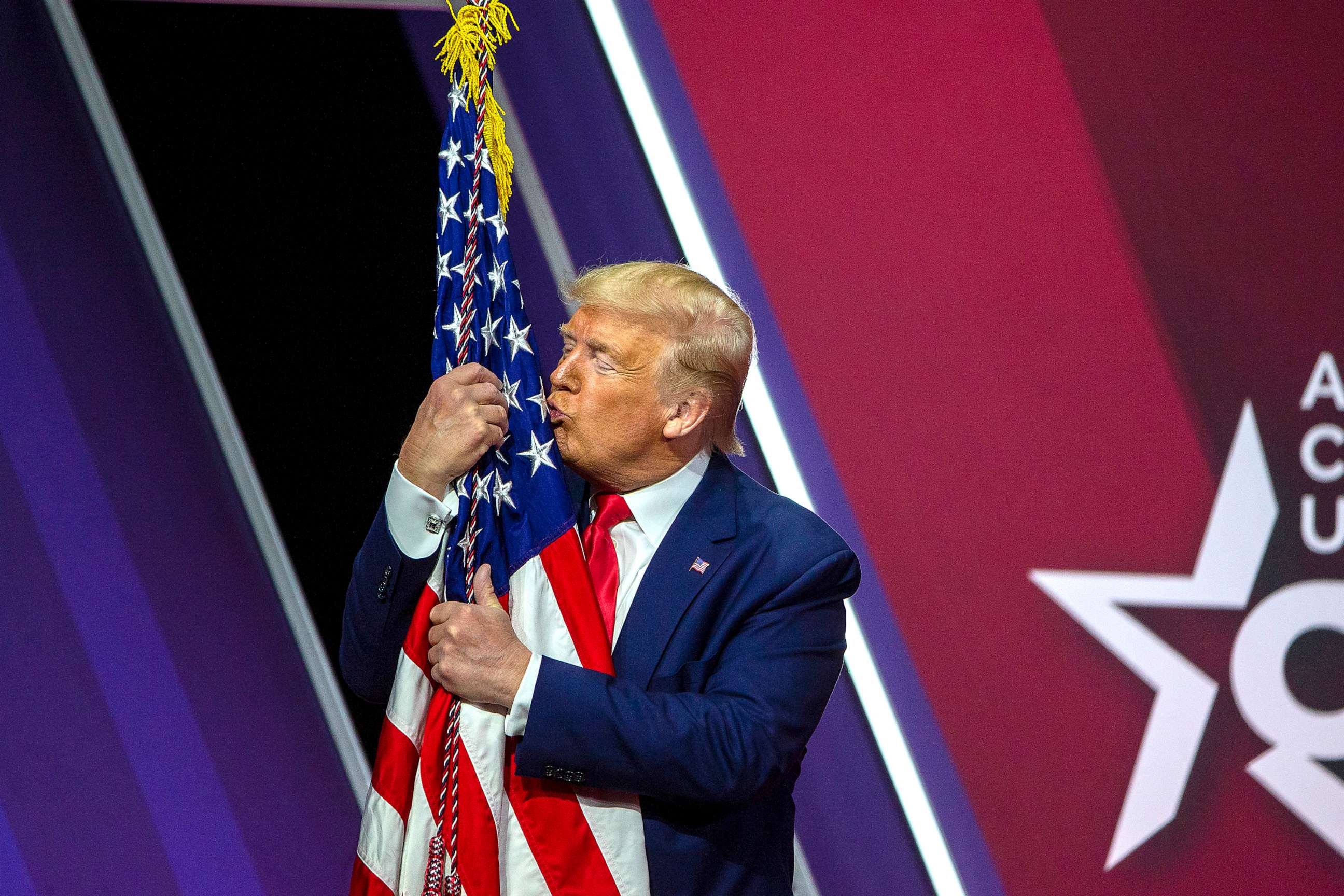 PHOTO: In this Feb. 29, 2020, file photo, President Donald Trump hugs kisses the flag of the United States of America at the annual Conservative Political Action Conference (CPAC) in National Harbor, Maryland.