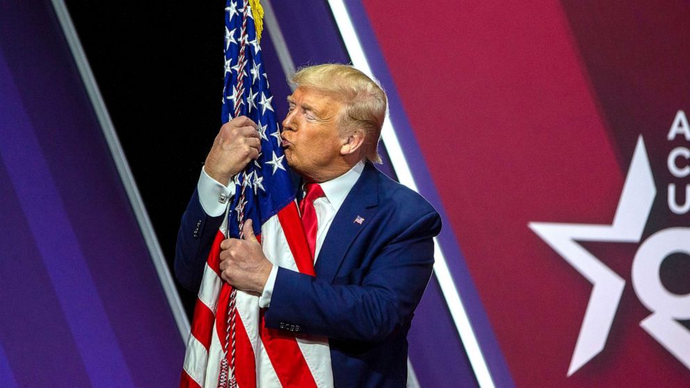 PHOTO: In this Feb. 29, 2020, file photo, President Donald Trump hugs kisses the flag of the United States of America at the annual Conservative Political Action Conference (CPAC) in National Harbor, Maryland.