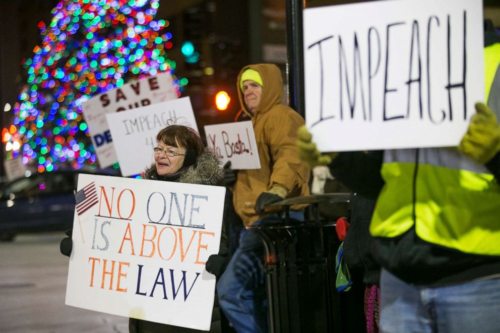 PHOTO: Jean Hotopp of Rockford, left, and dozens of other protesters hold signs and chant slogans advocating impeachment of President Donald Trump on Tuesday, Dec. 17, 2019, at the intersection of State Street and Wyman Street in Rockford. 