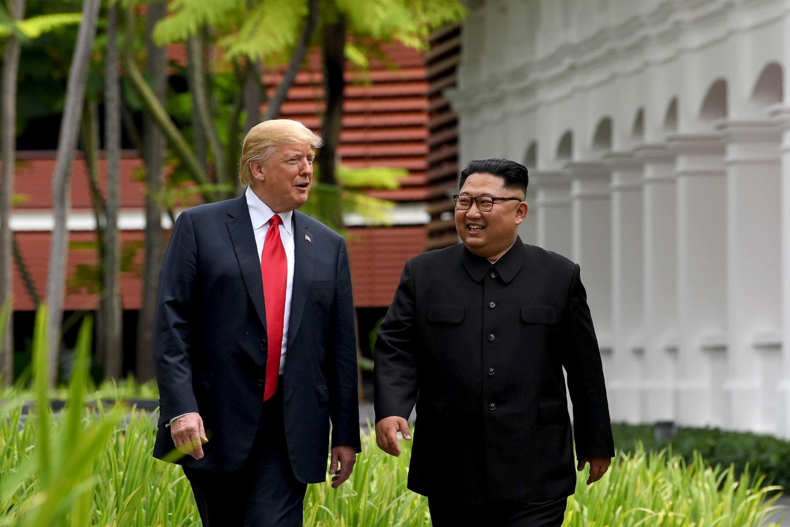 PHOTO: North Korea's leader Kim Jong Un walks with President Donald Trump, left, during a break in talks at their historic US-North Korea summit at the Capella Hotel on Sentosa island in Singapore, June 12, 2018.