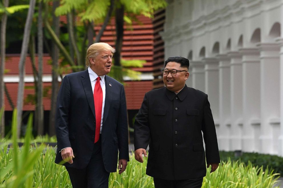 PHOTO: North Korea's leader Kim Jong Un, right, walks with President Donald Trump during a break in talks at their historic US-North Korea summit, at the Capella Hotel on Sentosa island in Singapore.