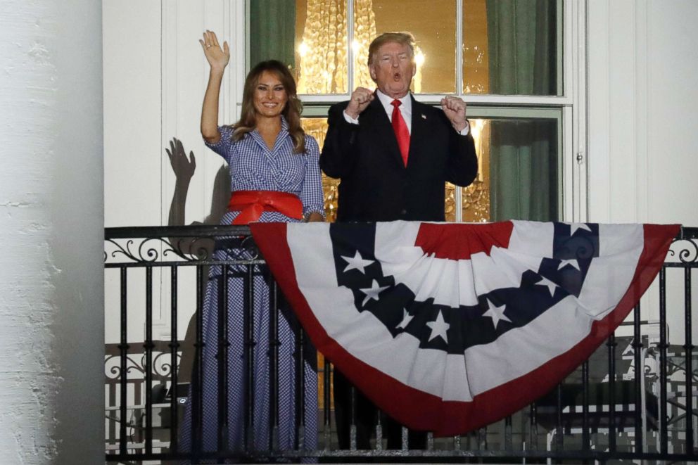 PHOTO: President Donald Trump, right, gestures as First Lady Melania Trump waves from a balcony of the White House during a fireworks display in Washington, D.C., July 4, 2018.