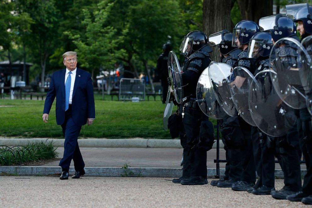 PHOTO: President Donald Trump walks past police in Lafayette Park after visiting the front of St. John's Church across from the White House in Washington, June 1, 2020.