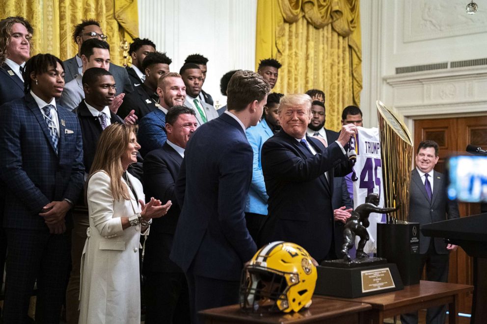 PHOTO: Louisiana State University quarterback Joe Burrow, presents President Donald Trump, with a jersey during an event to honor this year's NCAA football champions LSU Tigers in the East Room of the White House in Washington, Jan. 17, 2020.