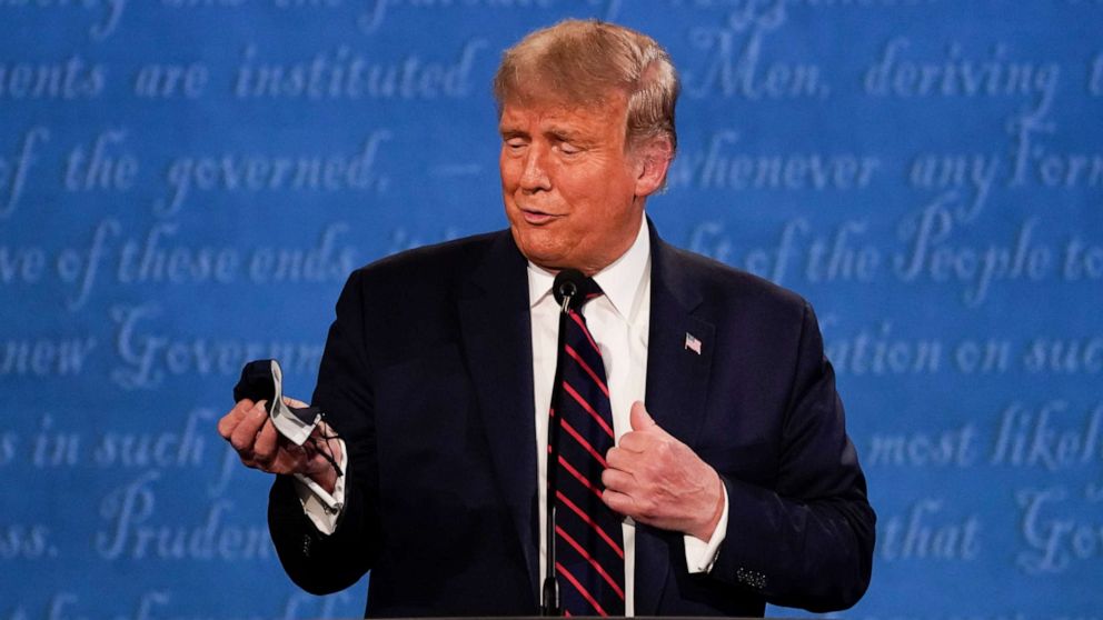 PHOTO: President Donald Trump holds out his face mask during the first presidential debate at Case Western University and Cleveland Clinic, in Cleveland, Ohio, Sept. 29, 2020.