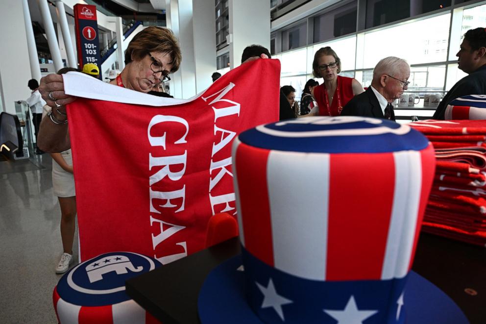 PHOTO: People look at political merchandise for sale on the first day of the Republican National Convention at the Fiserv Forum, July 15, 2024, in Milwaukee.
