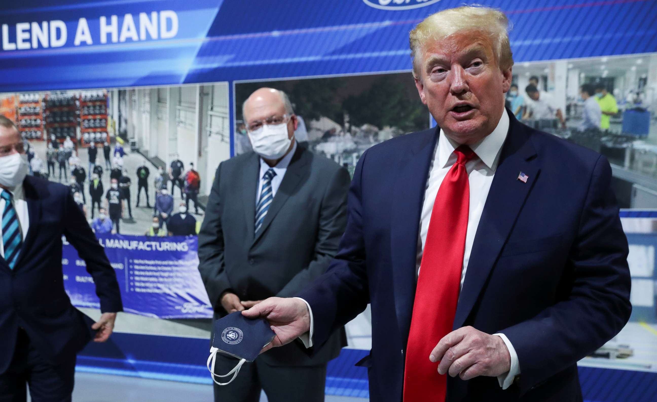 PHOTO: President Donald Trump holds a protective face mask with a presidential seal on it that he said he had been wearing earlier in his tour at the Ford Rawsonville Components Plant in Ypsilanti, Mich., May 21, 2020.