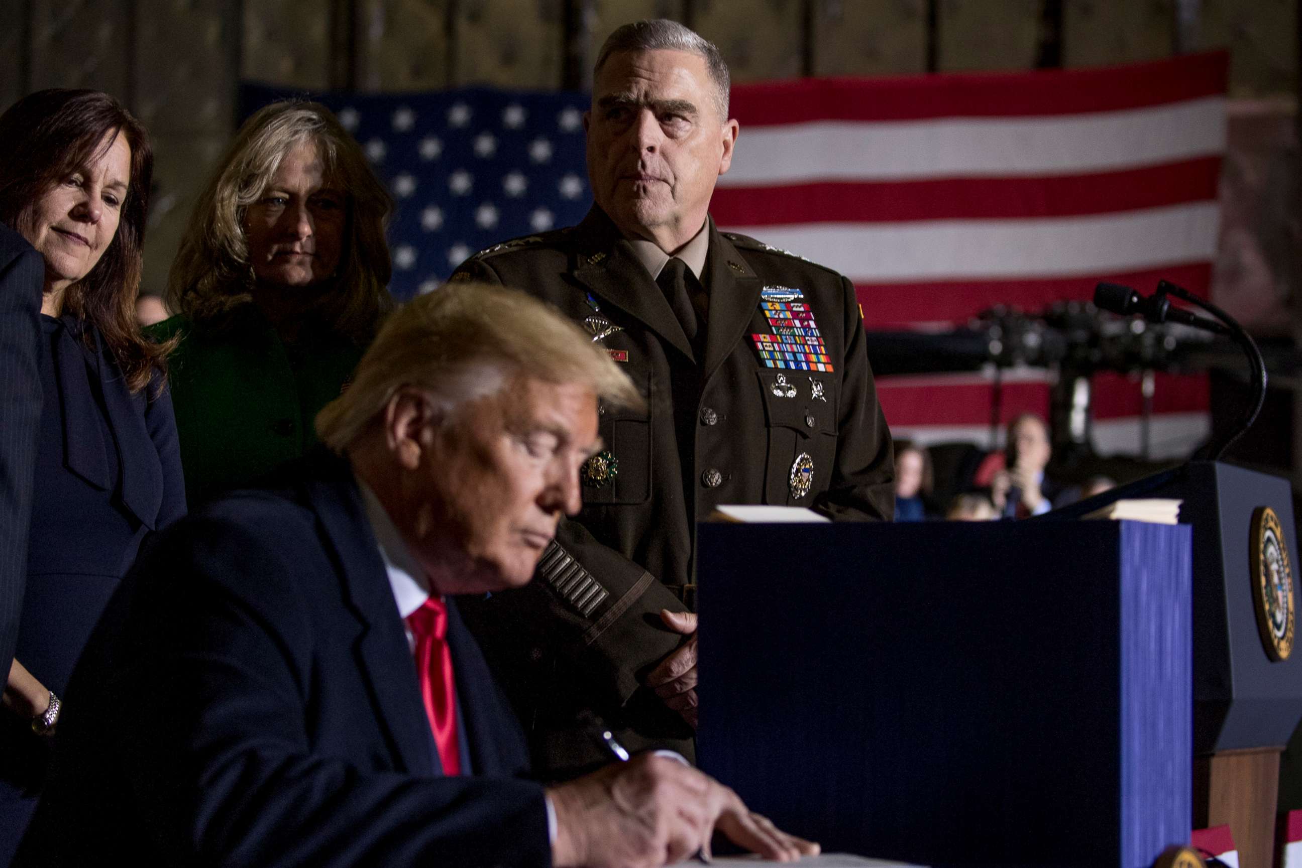 PHOTO: Joint Chiefs Chairman Gen. Mark Milley, top center, watches as President Donald Trump signs the National Defense Authorization Act for Fiscal Year 2020 at Andrews Air Force Base, Md., Dec. 20, 2019.