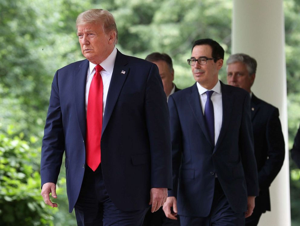 PHOTO: President Donald Trump walks into the Rose Garden to make a statement at the White House, May 29, 2020, followed by Treasury Secretary Steve Mnuchin, and others.