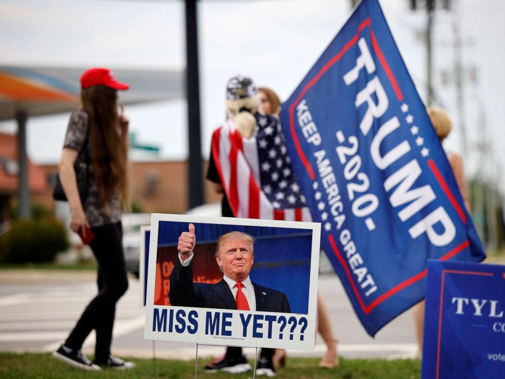 PHOTO: Supporters of former President Donald Trump gather on a street corner near a sign saying "Miss Me Yet???" outside the North Carolina GOP convention before Trump was expected to speak at the gathering in Greenville, N.C., June 5, 2021.