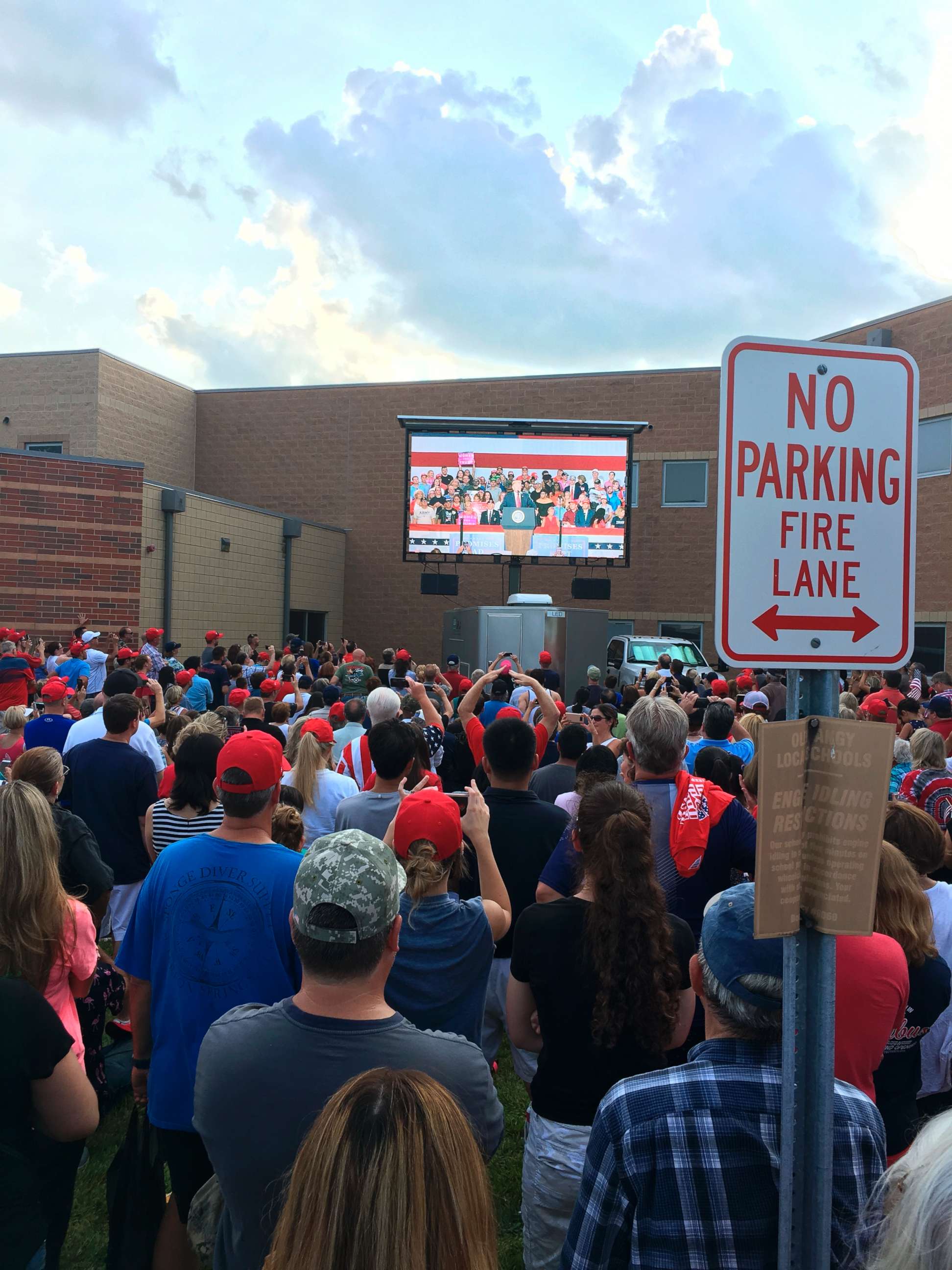 PHOTO: Hundreds of people in an outside overflow crowd watch President Donald Trump speak inside Olentangy Orange High School in Lewis Center, Ohio, Aug. 5, 2018.