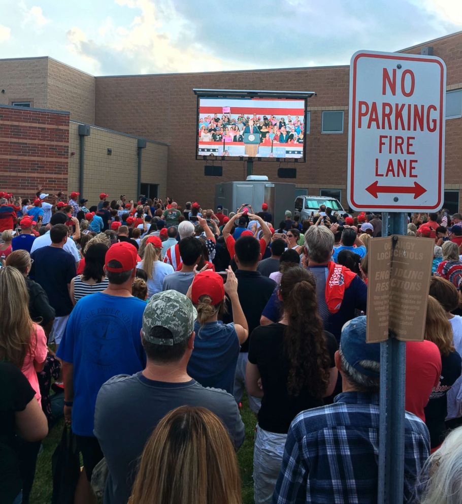 PHOTO: Hundreds of people in an outside overflow crowd watch President Donald Trump speak inside Olentangy Orange High School in Lewis Center, Ohio, Aug. 5, 2018.