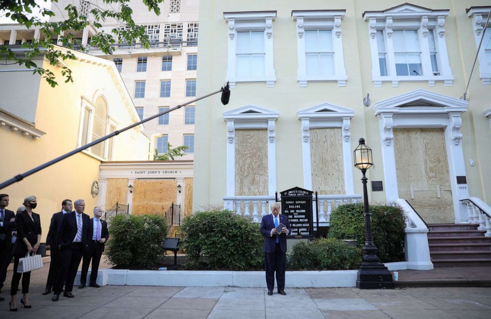 PHOTO: President Donald Trump looks at a Bible in front of St. John's Episcopal Church near the White House during a photo opportunity, as his daughter Ivanka and White House Chief of Staff Mark Meadows watch, June 1, 2020.